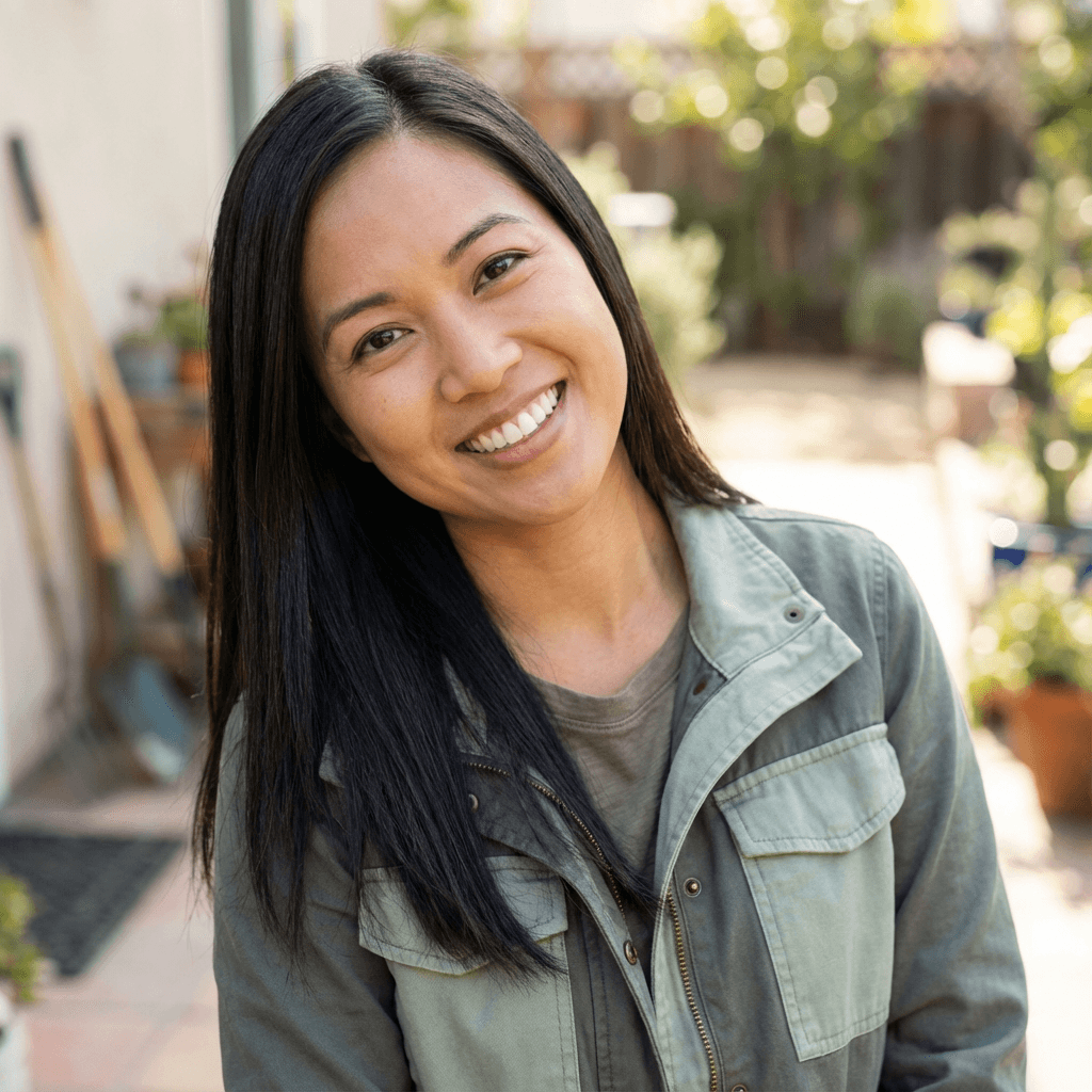 Female caregiver smiling in a tidy kitchen while preparing food